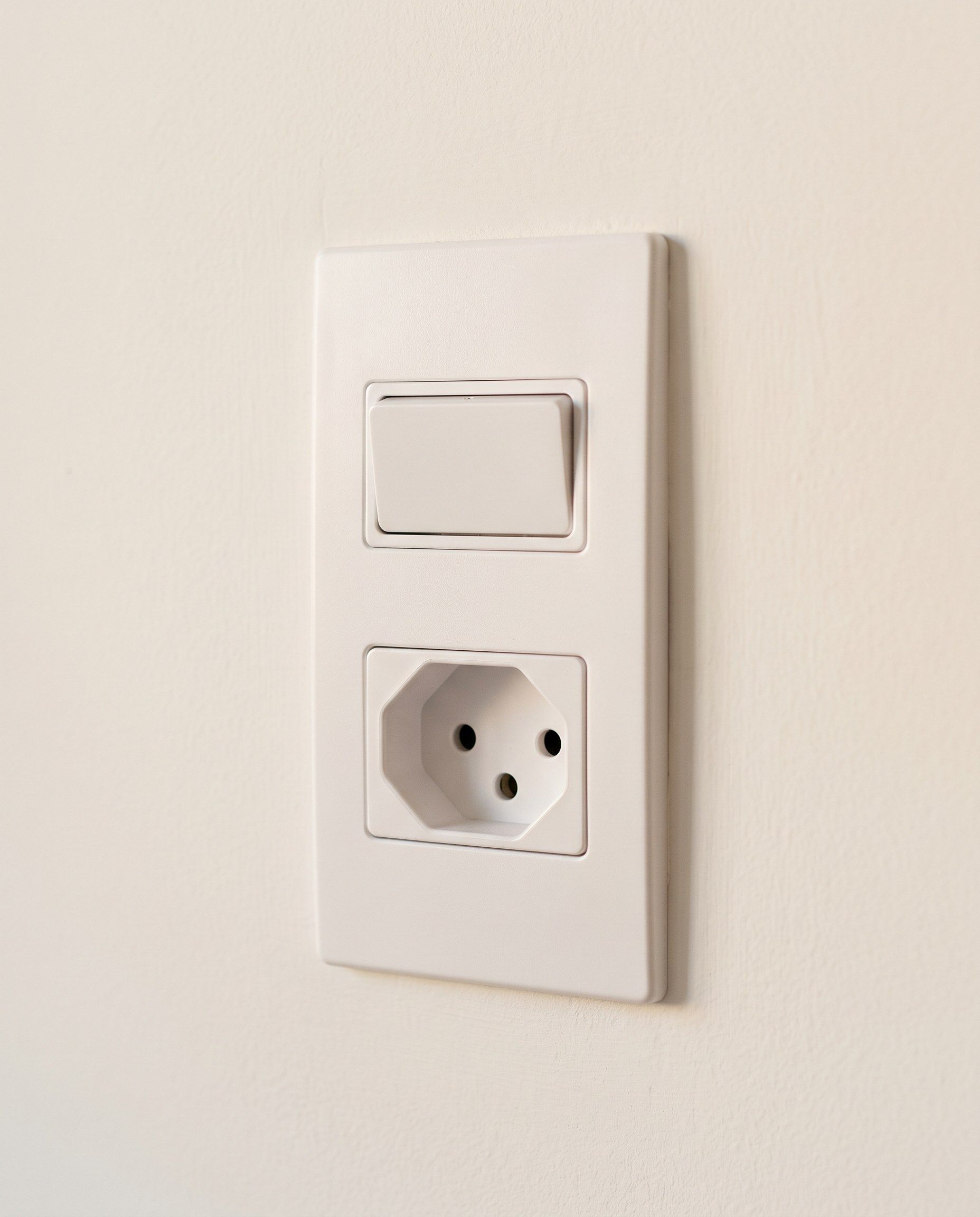 Eletricista instalando tomada de três pinos padrão brasileiro